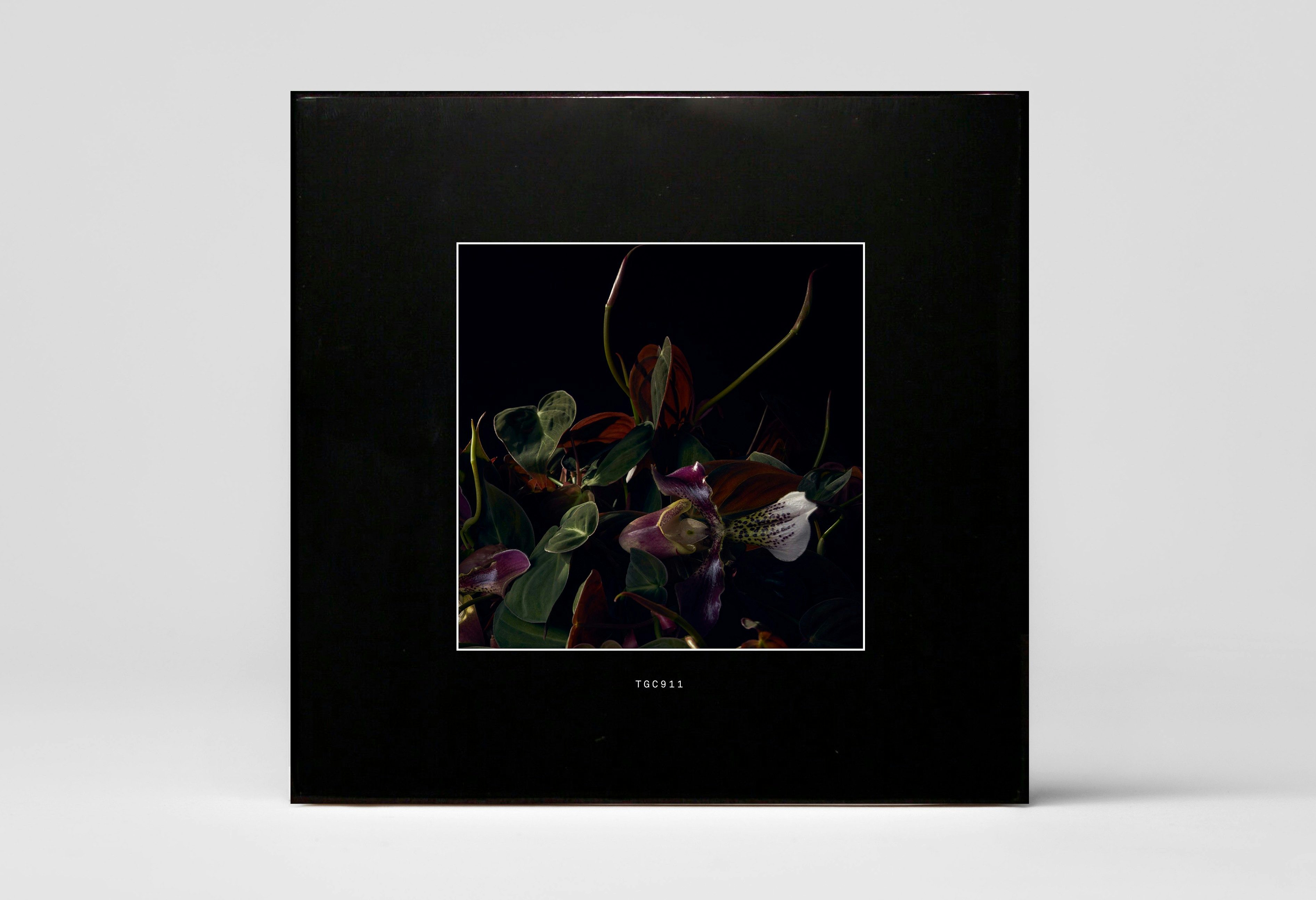 A black album cover with a photo of a floral arrangement in the center